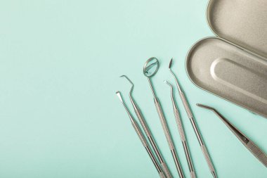 Mavi arkaplandaki dişçi aletleri. Diş hekimi konsepti. Diş bakımı, diş sağlığı konsepti. Ağız boşluğuna dikkat etmek anlamına geliyor. Diş modeli ve dişçi aletleri. Diş hijyeni. Mesaj için yer var. Boşluğu kopyala.