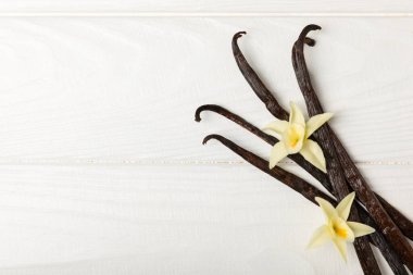 Dokulu bir arka planda vanilya kabukları. Vanilya çiçekleri ve tohumlar. Vanilyalı fasulye. Hamur işleri ve tatlılar için baharatlı baharat. Baharat. Mesaj için yer var. Boşluğu Kopyala