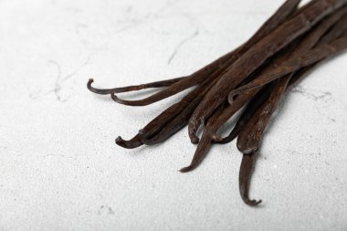 Dokulu bir arka planda vanilya kabukları. Vanilya çiçekleri ve tohumlar. Vanilyalı fasulye. Hamur işleri ve tatlılar için baharatlı baharat. Baharat. Mesaj için yer var. Boşluğu Kopyala