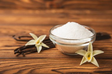 Aromatik vanilya şekeri. Vanilya kabukları. Vanilya çubukları, esmer ve beyaz şeker dokulu arka planda bir kasede. Vanilya çiçekleri, baharatlar ve tatlı ve pişirme için bitkiler. Mesaj için yer var. Boşluğu kopyala