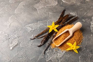 Aromatik vanilya şekeri. Vanilya kabukları. Vanilya çubukları, esmer ve beyaz şeker dokulu arka planda bir kasede. Vanilya çiçekleri, baharatlar ve tatlı ve pişirme için bitkiler. Mesaj için yer var. Boşluğu kopyala