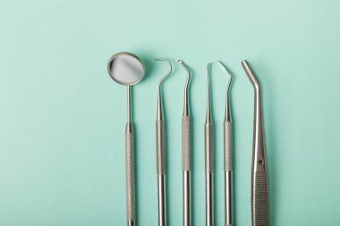 Mavi arkaplandaki dişçi aletleri. Diş hekimi konsepti. Diş bakımı, diş sağlığı konsepti. Ağız boşluğuna dikkat etmek anlamına geliyor. Diş modeli ve dişçi aletleri. Diş hijyeni. Mesaj için yer var. Boşluğu kopyala.