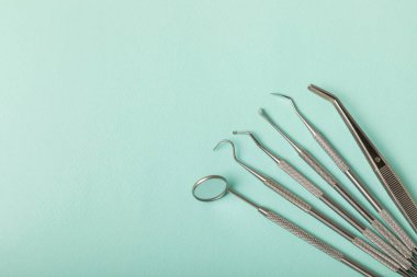 Mavi arkaplandaki dişçi aletleri. Diş hekimi konsepti. Diş bakımı, diş sağlığı konsepti. Ağız boşluğuna dikkat etmek anlamına geliyor. Diş modeli ve dişçi aletleri. Diş hijyeni. Mesaj için yer var. Boşluğu kopyala.