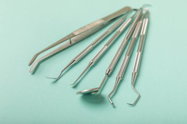 Mavi arkaplandaki dişçi aletleri. Diş hekimi konsepti. Diş bakımı, diş sağlığı konsepti. Ağız boşluğuna dikkat etmek anlamına geliyor. Diş modeli ve dişçi aletleri. Diş hijyeni. Mesaj için yer var. Boşluğu kopyala.