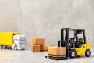 Parlak desenli arka planda sarı forklift. Lojistik konsept. Online alışveriş konsepti için lojistik ve tedarik zinciri yönetimi. Mağazaya mal ya da ürün teslimatı. Karton kutu.