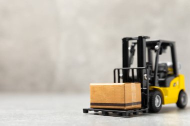 Parlak desenli arka planda sarı forklift. Lojistik konsept. Online alışveriş konsepti için lojistik ve tedarik zinciri yönetimi. Mağazaya mal ya da ürün teslimatı. Karton kutu.