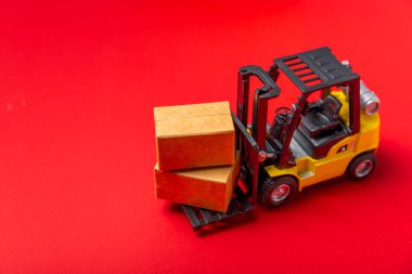 Parlak desenli arka planda sarı forklift. Lojistik konsept. Online alışveriş konsepti için lojistik ve tedarik zinciri yönetimi. Mağazaya mal ya da ürün teslimatı. Karton kutu.