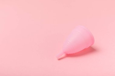 Aybaşı kupası, parlak bir arka plan. Hijyenik peçeteler, tamponlar ve regl kupası. Kritik günler, regl dönemi kavramı. Kadın hijyen ürünü. Kadın sağlığı kavramı. Adet öncesi sendromu. Boşluğu kopyala