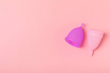 Aybaşı kupası, parlak bir arka plan. Hijyenik peçeteler, tamponlar ve regl kupası. Kritik günler, regl dönemi kavramı. Kadın hijyen ürünü. Kadın sağlığı kavramı. Adet öncesi sendromu. Boşluğu kopyala