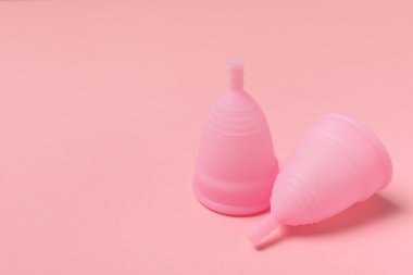 Aybaşı kupası, parlak bir arka plan. Hijyenik peçeteler, tamponlar ve regl kupası. Kritik günler, regl dönemi kavramı. Kadın hijyen ürünü. Kadın sağlığı kavramı. Adet öncesi sendromu. Boşluğu kopyala