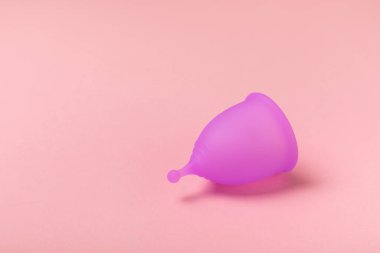 Aybaşı kupası, parlak bir arka plan. Hijyenik peçeteler, tamponlar ve regl kupası. Kritik günler, regl dönemi kavramı. Kadın hijyen ürünü. Kadın sağlığı kavramı. Adet öncesi sendromu. Boşluğu kopyala