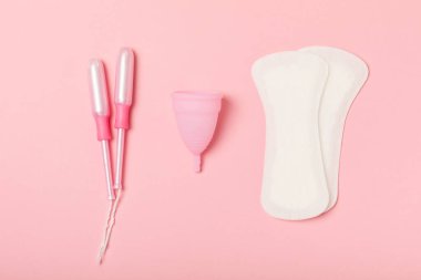 Aybaşı kupası, parlak bir arka plan. Hijyenik peçeteler, tamponlar ve regl kupası. Kritik günler, regl dönemi kavramı. Kadın hijyen ürünü. Kadın sağlığı kavramı. Adet öncesi sendromu. Boşluğu kopyala