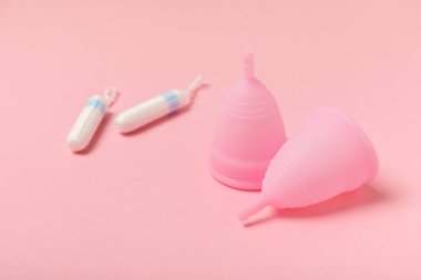 Aybaşı kupası, parlak bir arka plan. Hijyenik peçeteler, tamponlar ve regl kupası. Kritik günler, regl dönemi kavramı. Kadın hijyen ürünü. Kadın sağlığı kavramı. Adet öncesi sendromu. Boşluğu kopyala