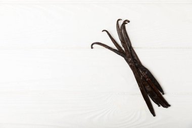 Dokulu bir arka planda vanilya kabukları. Vanilya çiçekleri ve tohumlar. Vanilyalı fasulye. Hamur işleri ve tatlılar için baharatlı baharat. Baharat. Mesaj için yer var. Boşluğu Kopyala