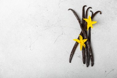 Dokulu bir arka planda vanilya kabukları. Vanilya çiçekleri ve tohumlar. Vanilyalı fasulye. Hamur işleri ve tatlılar için baharatlı baharat. Baharat. Mesaj için yer var. Boşluğu Kopyala