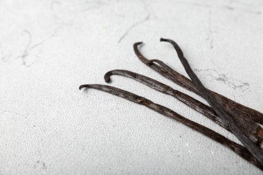 Dokulu bir arka planda vanilya kabukları. Vanilya çiçekleri ve tohumlar. Vanilyalı fasulye. Hamur işleri ve tatlılar için baharatlı baharat. Baharat. Mesaj için yer var. Boşluğu Kopyala