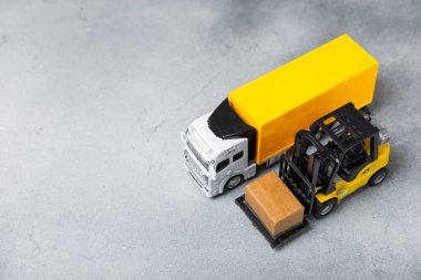 Parlak desenli arka planda sarı forklift. Lojistik konsept. Online alışveriş konsepti için lojistik ve tedarik zinciri yönetimi. Mağazaya mal ya da ürün teslimatı. Karton kutu.
