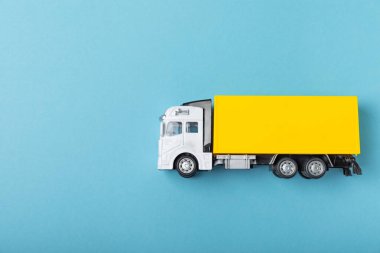 Parlak desenli arka planda sarı forklift. Lojistik konsept. Online alışveriş konsepti için lojistik ve tedarik zinciri yönetimi. Mağazaya mal ya da ürün teslimatı. Karton kutu.