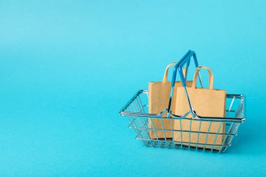 Çevrimiçi alışveriş kavramı. Karton kutu ve parlak renkli bir arka planda tramvayda alışveriş poşetleri. Alışveriş sepeti. İnternetten bilgisayar, tablet, telefon ve kredi kartı kullanarak alışveriş. Eve teslim.