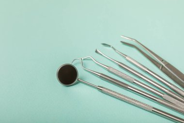 Mavi arkaplandaki dişçi aletleri. Diş hekimi konsepti. Diş bakımı, diş sağlığı konsepti. Ağız boşluğuna dikkat etmek anlamına geliyor. Diş modeli ve dişçi aletleri. Diş hijyeni. Mesaj için yer var. Boşluğu kopyala.