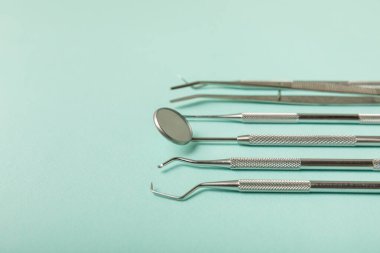 Mavi arkaplandaki dişçi aletleri. Diş hekimi konsepti. Diş bakımı, diş sağlığı konsepti. Ağız boşluğuna dikkat etmek anlamına geliyor. Diş modeli ve dişçi aletleri. Diş hijyeni. Mesaj için yer var. Boşluğu kopyala.