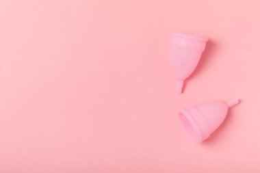 Aybaşı bardağı parlak bir arka planda. Hijyenik peçeteler, tamponlar ve regl kupası. Kritik günler, regl dönemi kavramı. Kadın hijyen ürünü. Kadın sağlığı kavramı. Adet öncesi sendromu. Boşluğu kopyala