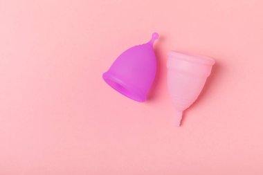 Aybaşı bardağı parlak bir arka planda. Hijyenik peçeteler, tamponlar ve regl kupası. Kritik günler, regl dönemi kavramı. Kadın hijyen ürünü. Kadın sağlığı kavramı. Adet öncesi sendromu. Boşluğu kopyala