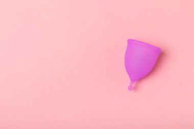 Aybaşı bardağı parlak bir arka planda. Hijyenik peçeteler, tamponlar ve regl kupası. Kritik günler, regl dönemi kavramı. Kadın hijyen ürünü. Kadın sağlığı kavramı. Adet öncesi sendromu. Boşluğu kopyala