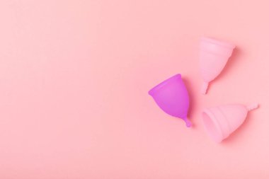 Aybaşı bardağı parlak bir arka planda. Hijyenik peçeteler, tamponlar ve regl kupası. Kritik günler, regl dönemi kavramı. Kadın hijyen ürünü. Kadın sağlığı kavramı. Adet öncesi sendromu. Boşluğu kopyala