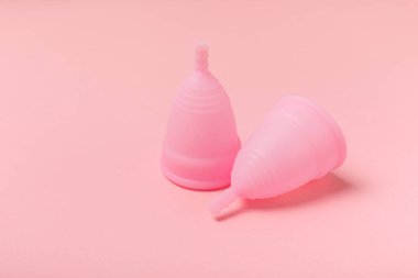 Aybaşı bardağı parlak bir arka planda. Hijyenik peçeteler, tamponlar ve regl kupası. Kritik günler, regl dönemi kavramı. Kadın hijyen ürünü. Kadın sağlığı kavramı. Adet öncesi sendromu. Boşluğu kopyala