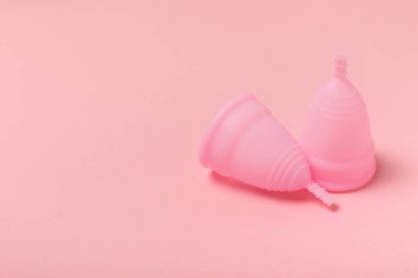 Aybaşı bardağı parlak bir arka planda. Hijyenik peçeteler, tamponlar ve regl kupası. Kritik günler, regl dönemi kavramı. Kadın hijyen ürünü. Kadın sağlığı kavramı. Adet öncesi sendromu. Boşluğu kopyala