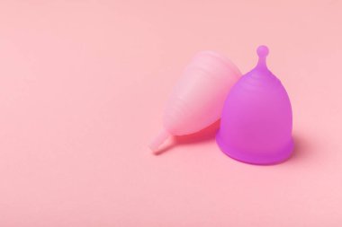 Aybaşı bardağı parlak bir arka planda. Hijyenik peçeteler, tamponlar ve regl kupası. Kritik günler, regl dönemi kavramı. Kadın hijyen ürünü. Kadın sağlığı kavramı. Adet öncesi sendromu. Boşluğu kopyala