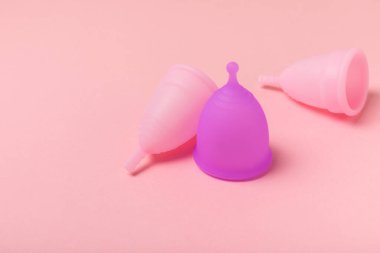 Aybaşı bardağı parlak bir arka planda. Hijyenik peçeteler, tamponlar ve regl kupası. Kritik günler, regl dönemi kavramı. Kadın hijyen ürünü. Kadın sağlığı kavramı. Adet öncesi sendromu. Boşluğu kopyala