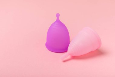 Aybaşı bardağı parlak bir arka planda. Hijyenik peçeteler, tamponlar ve regl kupası. Kritik günler, regl dönemi kavramı. Kadın hijyen ürünü. Kadın sağlığı kavramı. Adet öncesi sendromu. Boşluğu kopyala