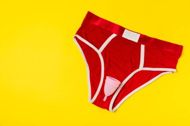 Aybaşı bardağı parlak bir arka planda. Hijyenik peçeteler, tamponlar ve regl kupası. Kritik günler, regl dönemi kavramı. Kadın hijyen ürünü. Kadın sağlığı kavramı. Adet öncesi sendromu. Boşluğu kopyala