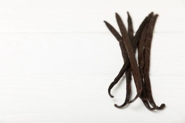 Dokulu bir arka planda vanilya kabukları. Vanilya çiçekleri ve tohumlar. Vanilyalı fasulye. Hamur işleri ve tatlılar için baharatlı baharat. Baharat. Mesaj için yer var. Boşluğu Kopyala