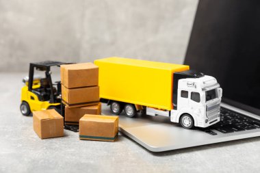Sarı forklift ve parlak arka planda sarı kamyon. Lojistik konsept. Online alışveriş için lojistik ve tedarik zinciri yönetimi. Mağazaya mal ya da ürün teslimatı. Karton kutu..