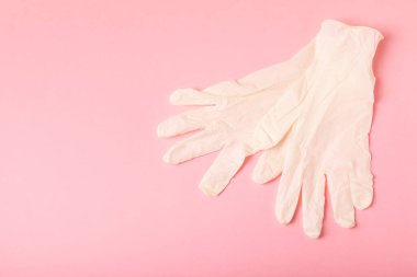 Tıbbi nitril eldivenler, mavi başlık, desenli arka planda tek kullanımlık tıbbi maske. Tıbbi koruyucu giysi. Cerrahi lateks eldivenler. Lastik eldiven üretimi. Tıp konsepti. Üst Manzara. Metni kopyala