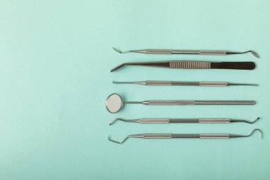 Mavi arkaplandaki dişçi aletleri. Diş hekimi konsepti. Diş bakımı, diş sağlığı konsepti. Ağız boşluğuna dikkat etmek anlamına geliyor. Diş modeli ve dişçi aletleri. Diş hijyeni. Mesaj için yer var. Boşluğu kopyala.