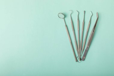 Mavi arkaplandaki dişçi aletleri. Diş hekimi konsepti. Diş bakımı, diş sağlığı konsepti. Ağız boşluğuna dikkat etmek anlamına geliyor. Diş modeli ve dişçi aletleri. Diş hijyeni. Mesaj için yer var. Boşluğu kopyala.