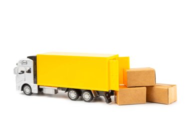 Sarı kamyonlar ve karton kutular beyaz arka planda izole edilmiş. Lojistik, teslimat ve ulaşım konuları. Dünyanın dört bir yanındaki mağazaya mal ya da ürün teslimatı. Karton kutu..
