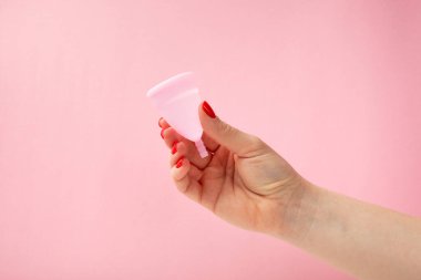 Aybaşı bardağı parlak bir arka planda. Hijyenik peçeteler, tamponlar ve regl kupası. Kritik günler, regl dönemi kavramı. Kadın hijyen ürünü. Kadın sağlığı kavramı. Adet öncesi sendromu. Boşluğu kopyala