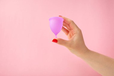 Aybaşı bardağı parlak bir arka planda. Hijyenik peçeteler, tamponlar ve regl kupası. Kritik günler, regl dönemi kavramı. Kadın hijyen ürünü. Kadın sağlığı kavramı. Adet öncesi sendromu. Boşluğu kopyala