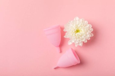 Aybaşı bardağı parlak bir arka planda. Hijyenik peçeteler, tamponlar ve regl kupası. Kritik günler, regl dönemi kavramı. Kadın hijyen ürünü. Kadın sağlığı kavramı. Adet öncesi sendromu. Boşluğu kopyala