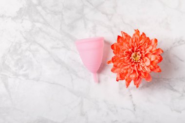 Aybaşı bardağı parlak bir arka planda. Hijyenik peçeteler, tamponlar ve regl kupası. Kritik günler, regl dönemi kavramı. Kadın hijyen ürünü. Kadın sağlığı kavramı. Adet öncesi sendromu. Boşluğu kopyala