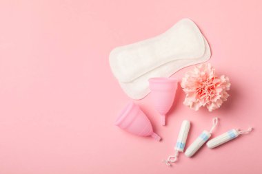 Aybaşı bardağı parlak bir arka planda. Hijyenik peçeteler, tamponlar ve regl kupası. Kritik günler, regl dönemi kavramı. Kadın hijyen ürünü. Kadın sağlığı kavramı. Adet öncesi sendromu. Boşluğu kopyala