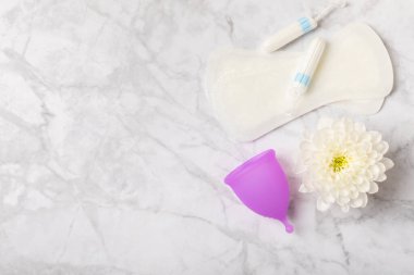 Aybaşı bardağı parlak bir arka planda. Hijyenik peçeteler, tamponlar ve regl kupası. Kritik günler, regl dönemi kavramı. Kadın hijyen ürünü. Kadın sağlığı kavramı. Adet öncesi sendromu. Boşluğu kopyala