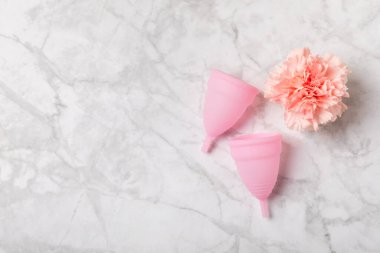 Aybaşı bardağı parlak bir arka planda. Hijyenik peçeteler, tamponlar ve regl kupası. Kritik günler, regl dönemi kavramı. Kadın hijyen ürünü. Kadın sağlığı kavramı. Adet öncesi sendromu. Boşluğu kopyala