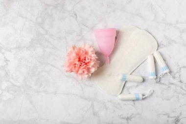 Aybaşı bardağı parlak bir arka planda. Hijyenik peçeteler, tamponlar ve regl kupası. Kritik günler, regl dönemi kavramı. Kadın hijyen ürünü. Kadın sağlığı kavramı. Adet öncesi sendromu. Boşluğu kopyala