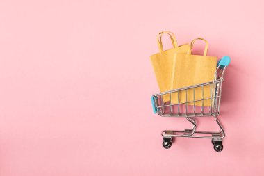 Çevrimiçi alışveriş kavramı. Karton kutu ve parlak renkli bir arka planda tramvayda alışveriş poşetleri. Alışveriş sepeti. İnternetten bilgisayar, tablet, telefon ve kredi kartı kullanarak alışveriş. Eve teslim.